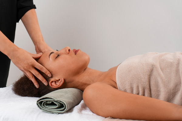 woman laying on table receiving head massage